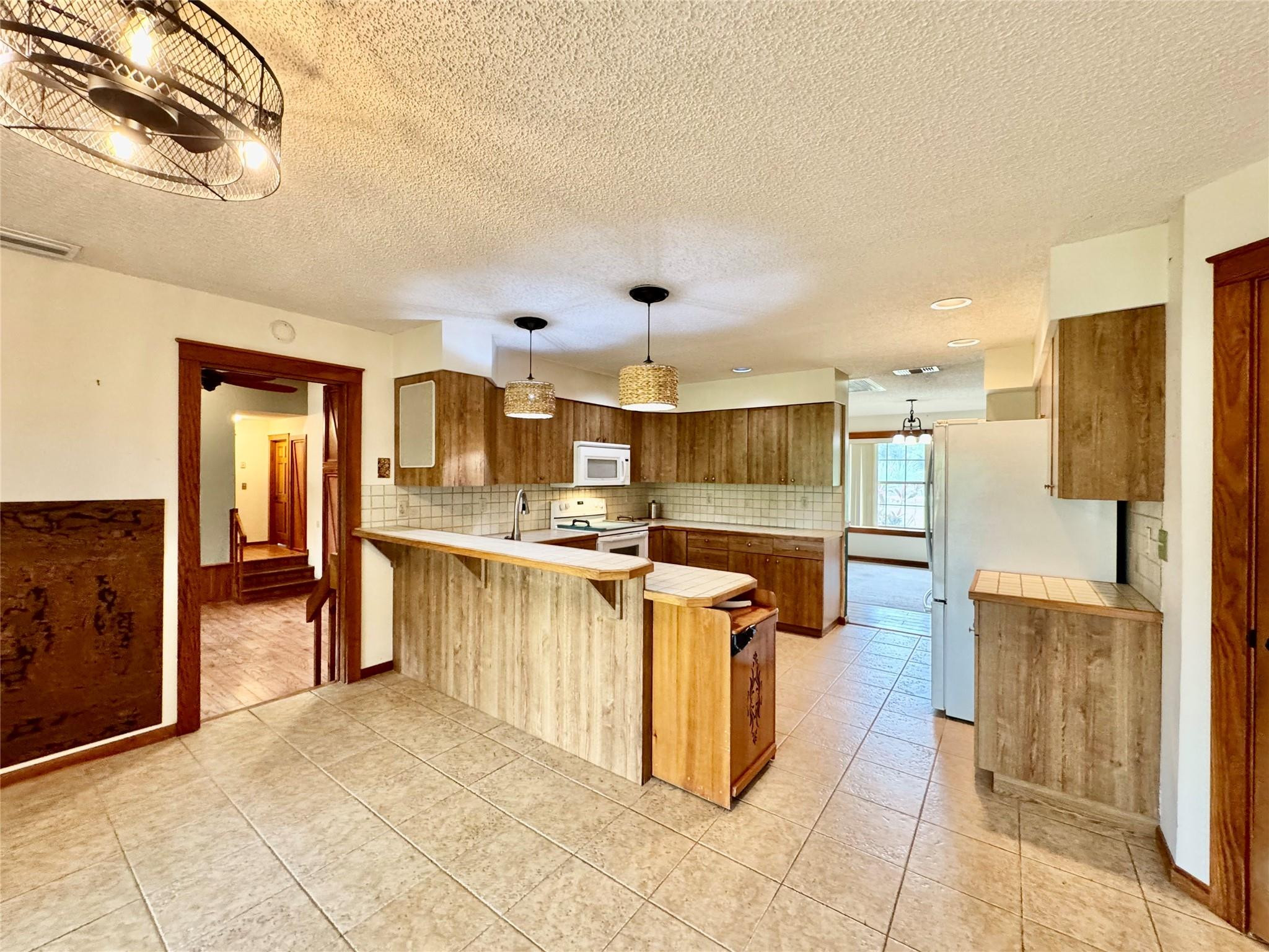 395 Southwest 30th Terrace Okeechobee, FL 34974 - Photo 14 of 57 a kitchen with stainless steel appliances kitchen island granite countertop a refrigerator and a stove