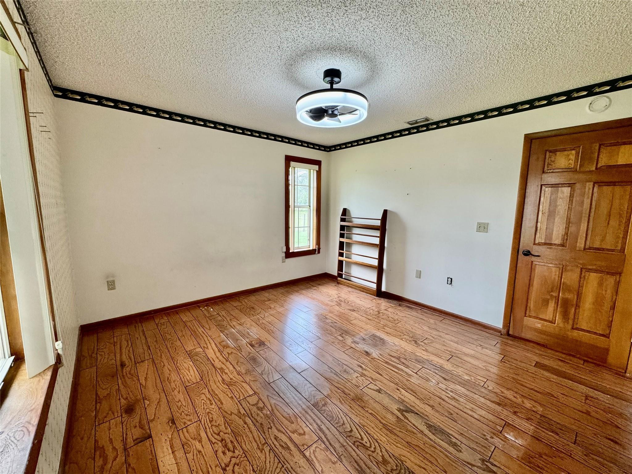 395 Southwest 30th Terrace Okeechobee, FL 34974 - Photo 29 of 57 a view of an empty room with wooden floor and a window