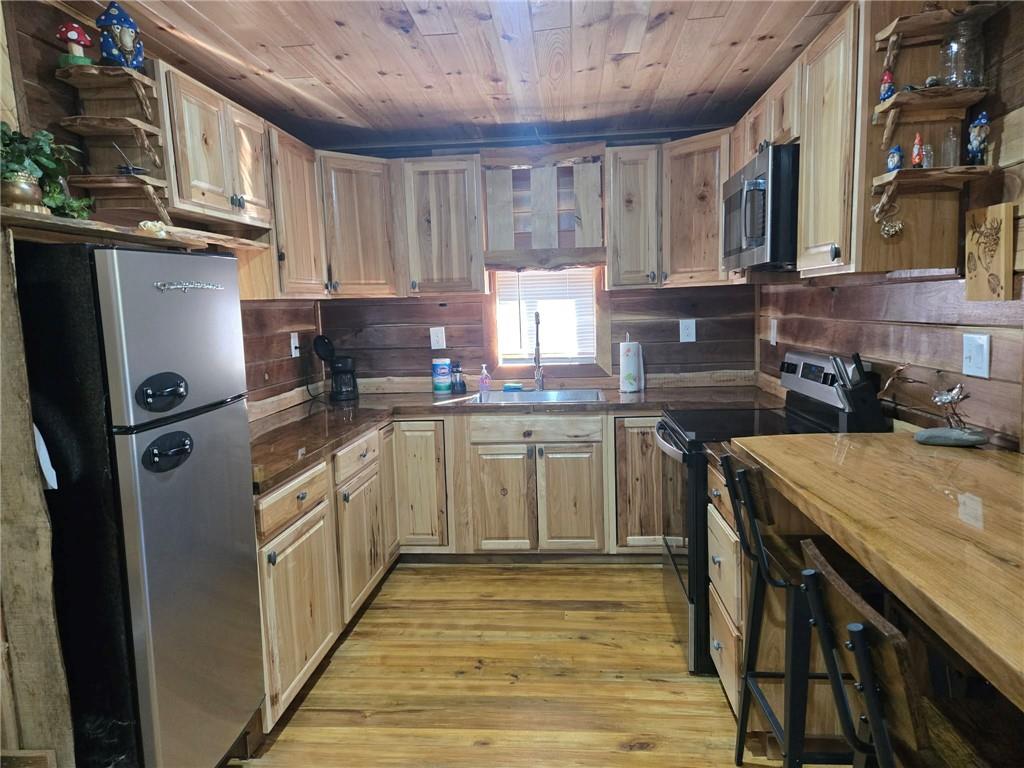 389 Winslow Hill Road Benezett, PA 15821 - Photo 4 of 33 a kitchen with a sink a stove cabinets and a wooden floor