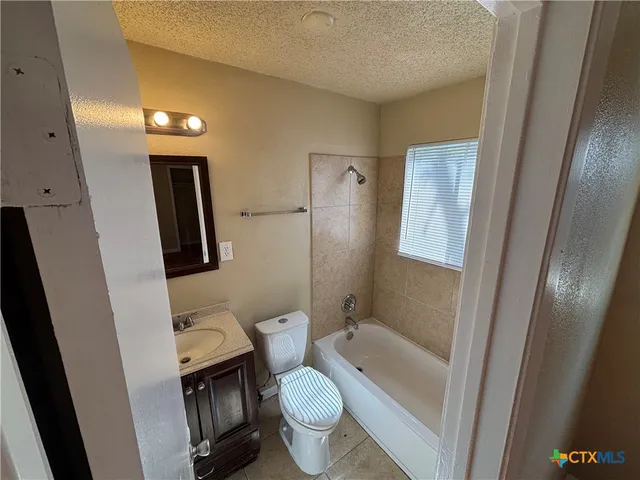 a bathroom with a granite countertop toilet sink and shower