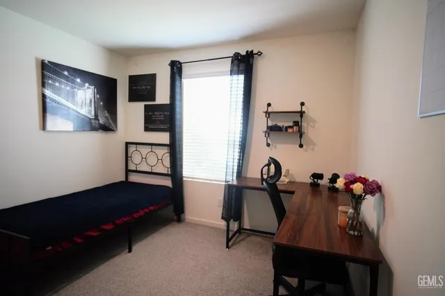 a view of a workspace with furniture and a window