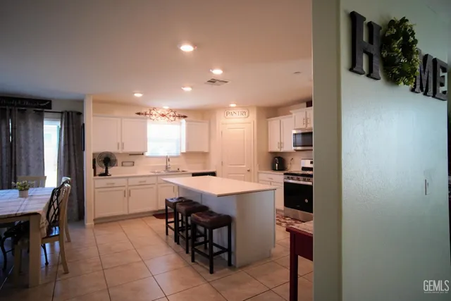 a kitchen with stainless steel appliances granite countertop a refrigerator and a stove