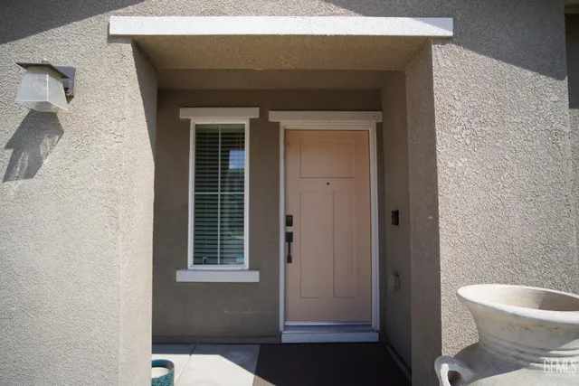 a view of a room with front door wooden floor and windows