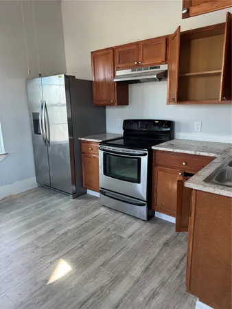 a kitchen with stainless steel appliances granite countertop a stove a sink and a refrigerator