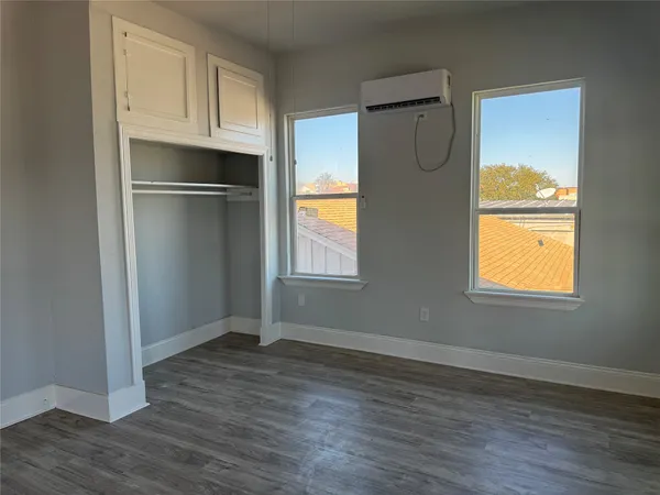 a view of empty room with wooden floor and cabinets