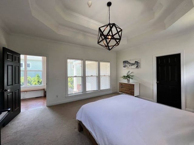 a bedroom with a bed and a chandelier