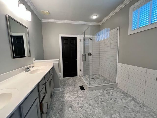 a bathroom with a double vanity sink mirror and shower