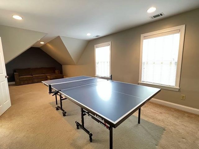 a room with pool table windows and wooden floor