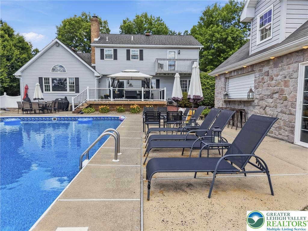 890 Lahr Road Nazareth, PA 18064 - Photo 51 of 71 A private backyard oasis features an inviting pool, spacious deck, and a stone outdoor kitchen.