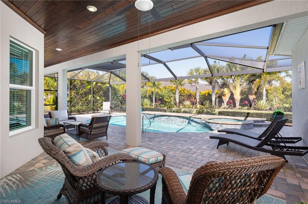 14627 Nicholas Way Naples, FL 34109 - Photo 21 of 27 a living room with patio furniture and a floor to ceiling window