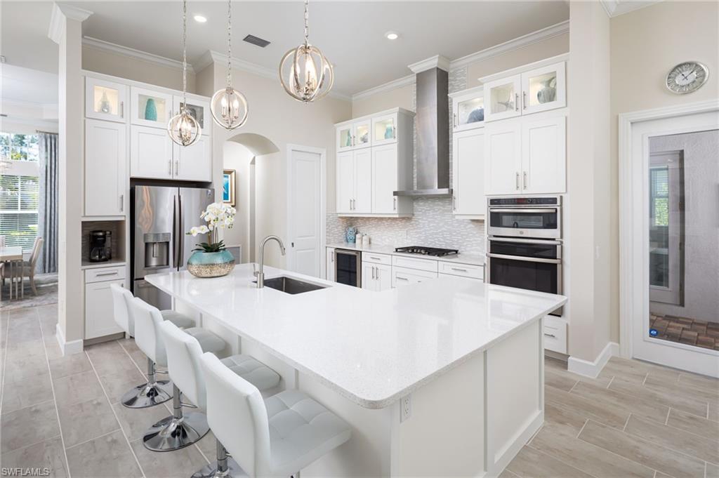 14627 Nicholas Way Naples, FL 34109 - Photo 7 of 27 a large kitchen with kitchen island a stove a sink dishwasher and a refrigerator with wooden floor