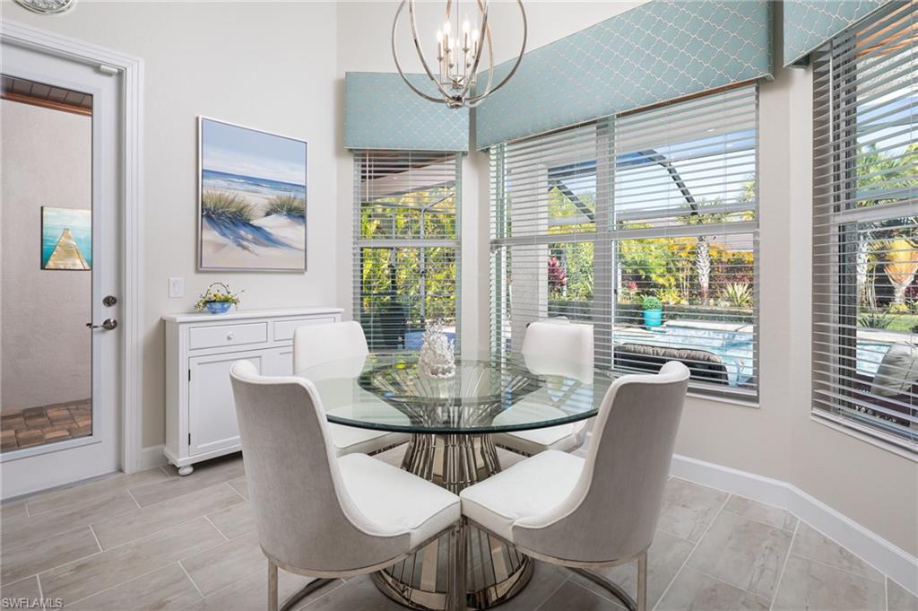 14627 Nicholas Way Naples, FL 34109 - Photo 9 of 27 a dining room with furniture a chandelier and wooden floor