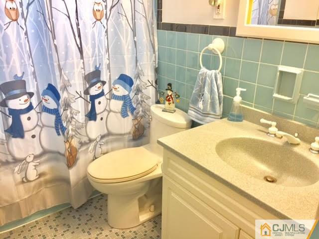 53 Albemarle Road Colonia, NJ 07067 - Photo 13 of 25 a bathroom with a sink and mirror with toilet