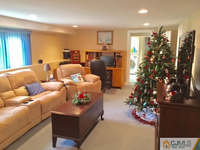 53 Albemarle Road Colonia, NJ 07067 - Photo 3 of 25 a living room with furniture flowers and a chandelier