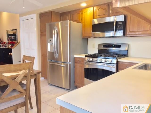 53 Albemarle Road Colonia, NJ 07067 - Photo 21 of 25 a kitchen with stainless steel appliances a refrigerator a stove a microwave and dining table