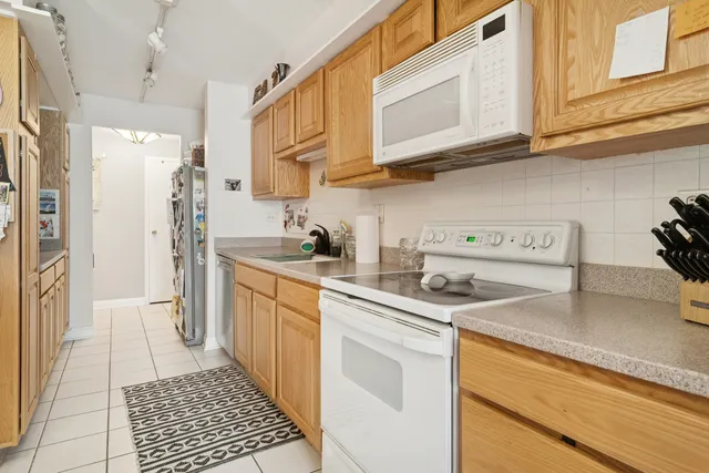 a kitchen with stainless steel appliances granite countertop a sink a stove a refrigerator and cabinets