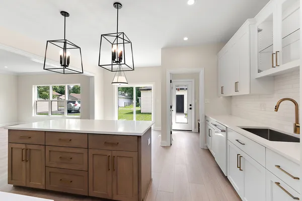 a kitchen with kitchen island granite countertop a sink stainless steel appliances and cabinets