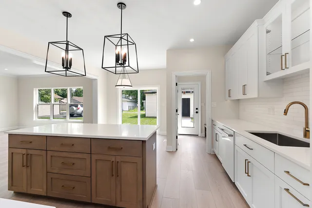 a kitchen that has a lot of cabinets and stainless steel appliances
