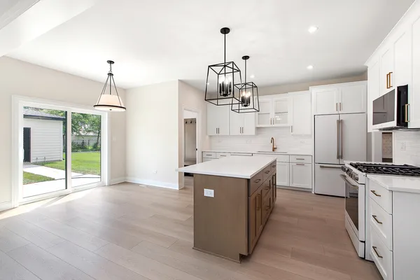 a kitchen that has a lot of cabinets and stainless steel appliances