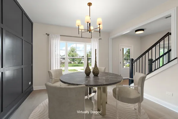 a dining room with furniture a chandelier and wooden floor
