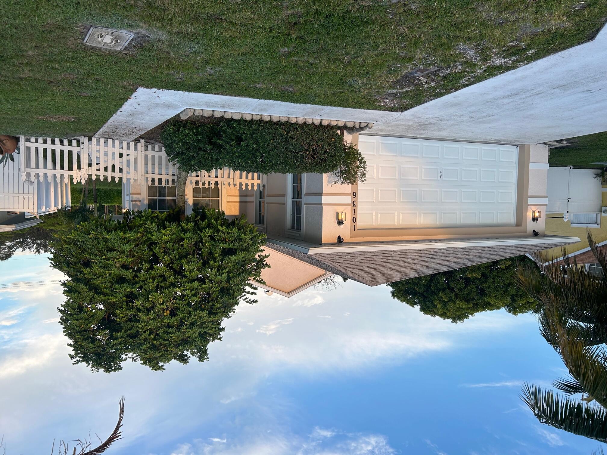 a front view of a house with a garden and plants