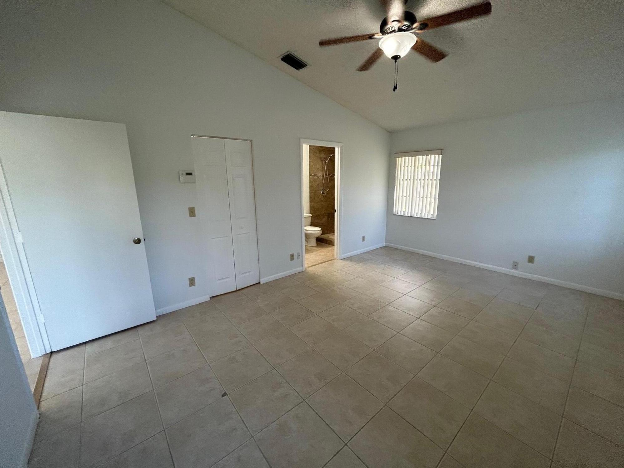 10136 Boynton Pl Circle Boynton Beach, FL 33437 - Photo 7 of 12 en empty room with windows and ceiling fan