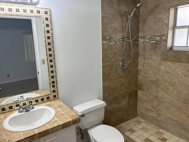 a bathroom with a sink toilet and shower