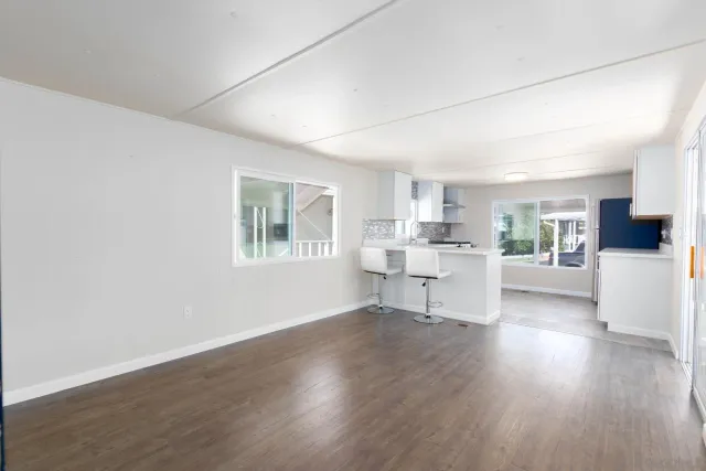 a view of a kitchen with wooden floor and a window