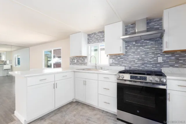 a kitchen with granite countertop white cabinets stainless steel appliances and sink