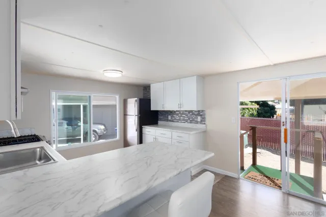 a kitchen with stainless steel appliances kitchen island granite countertop a refrigerator a stove and a sink with granite countertops