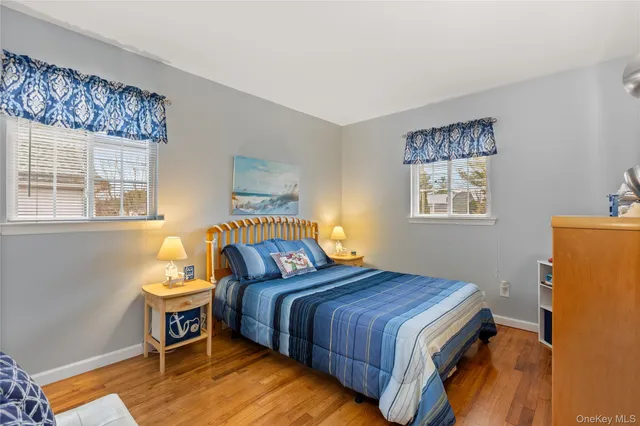a bedroom with a bed and a dresser next to a window