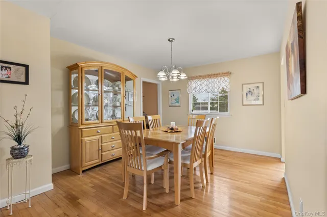 a dining room with furniture a chandelier and wooden floor