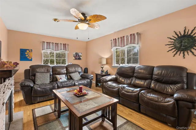 a living room with furniture kitchen view and a large window