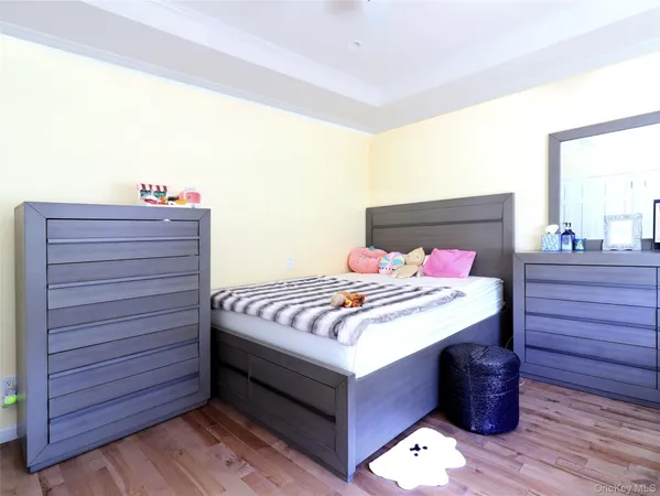 a bedroom with bed and wooden floor