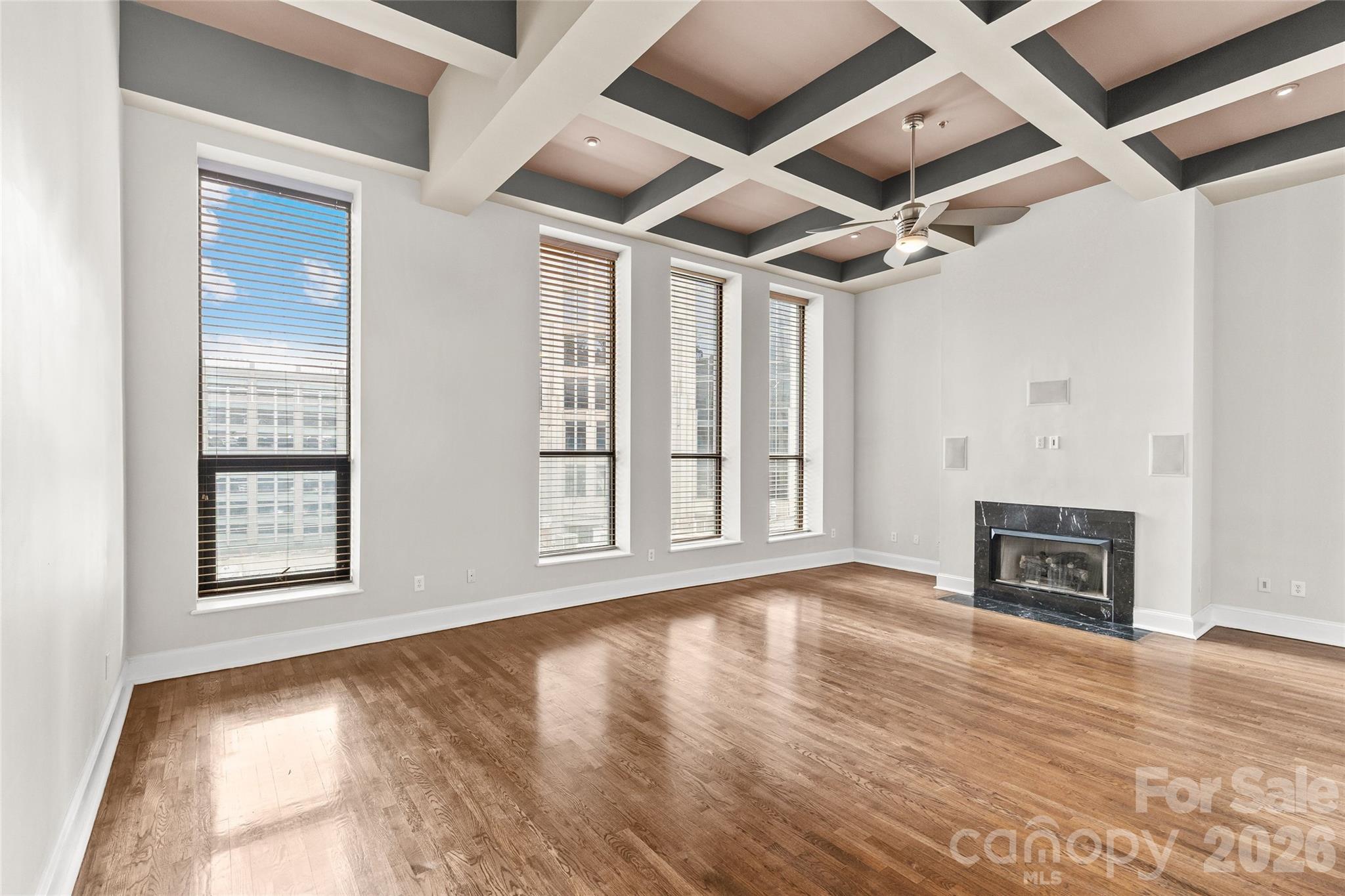 127 North Tryon Street, Unit 410 Charlotte, NC 28246 - Photo 19 of 37 a view of an empty room with wooden floor fireplace and a window