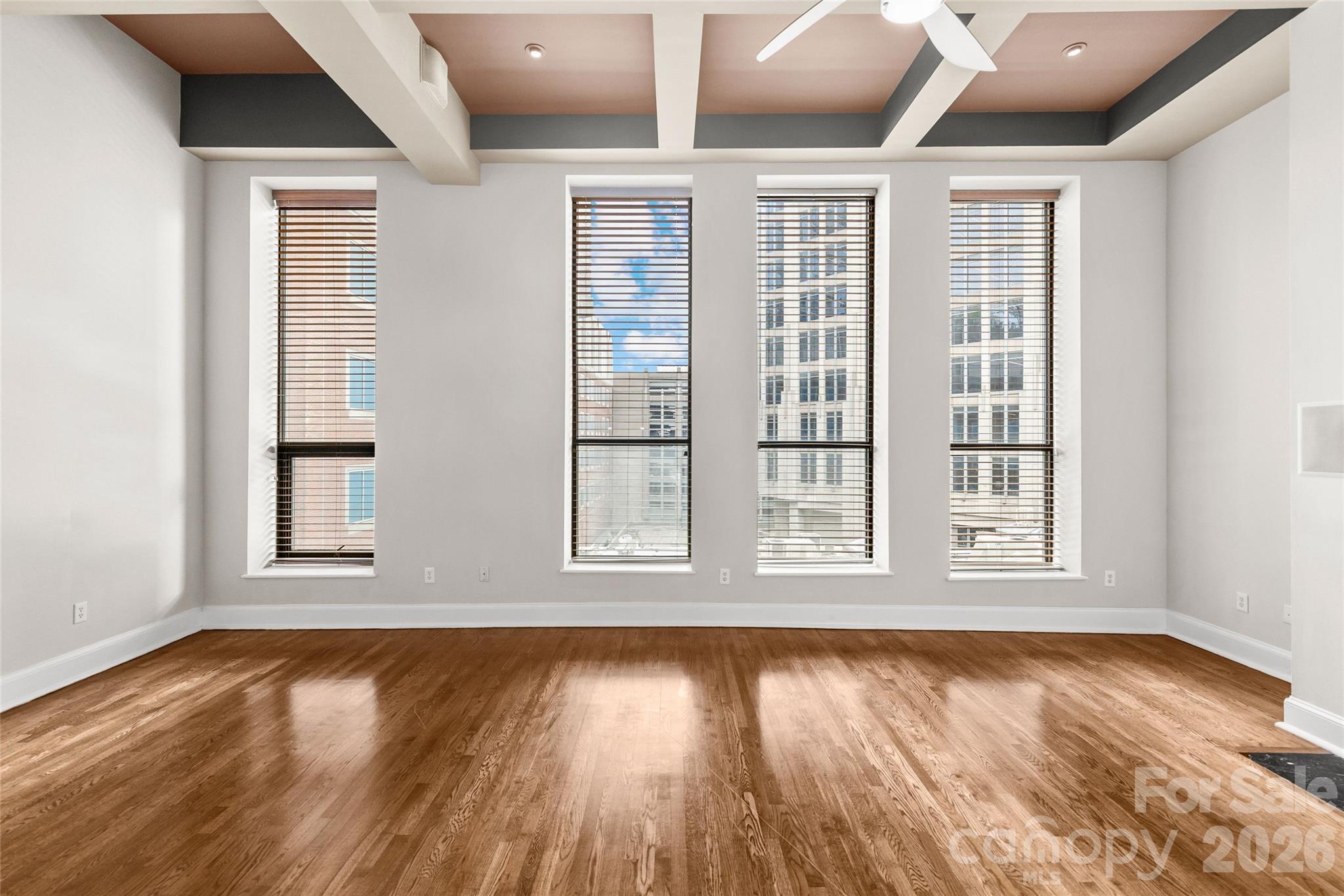 127 North Tryon Street, Unit 410 Charlotte, NC 28246 - Photo 21 of 37 an empty room with wooden floor and windows