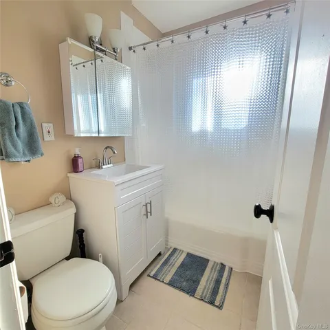 a bathroom with a sink toilet vanity and tub