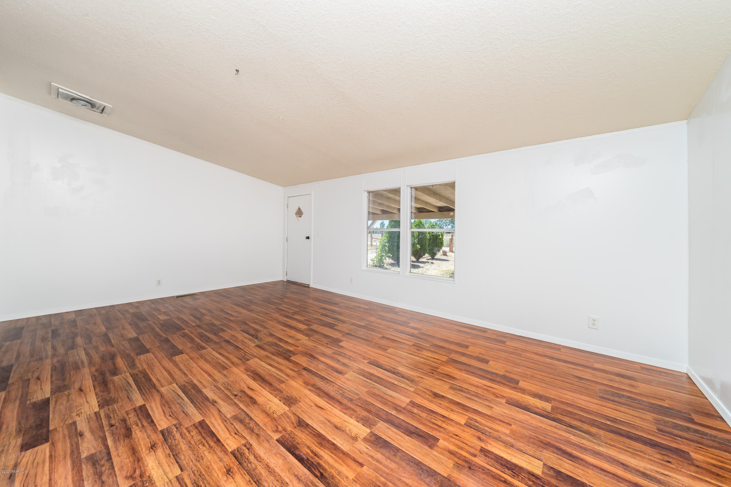 25125 North Mitchell Road Paulden, AZ 86334 - Photo 4 of 18 an empty room with wooden floor and windows
