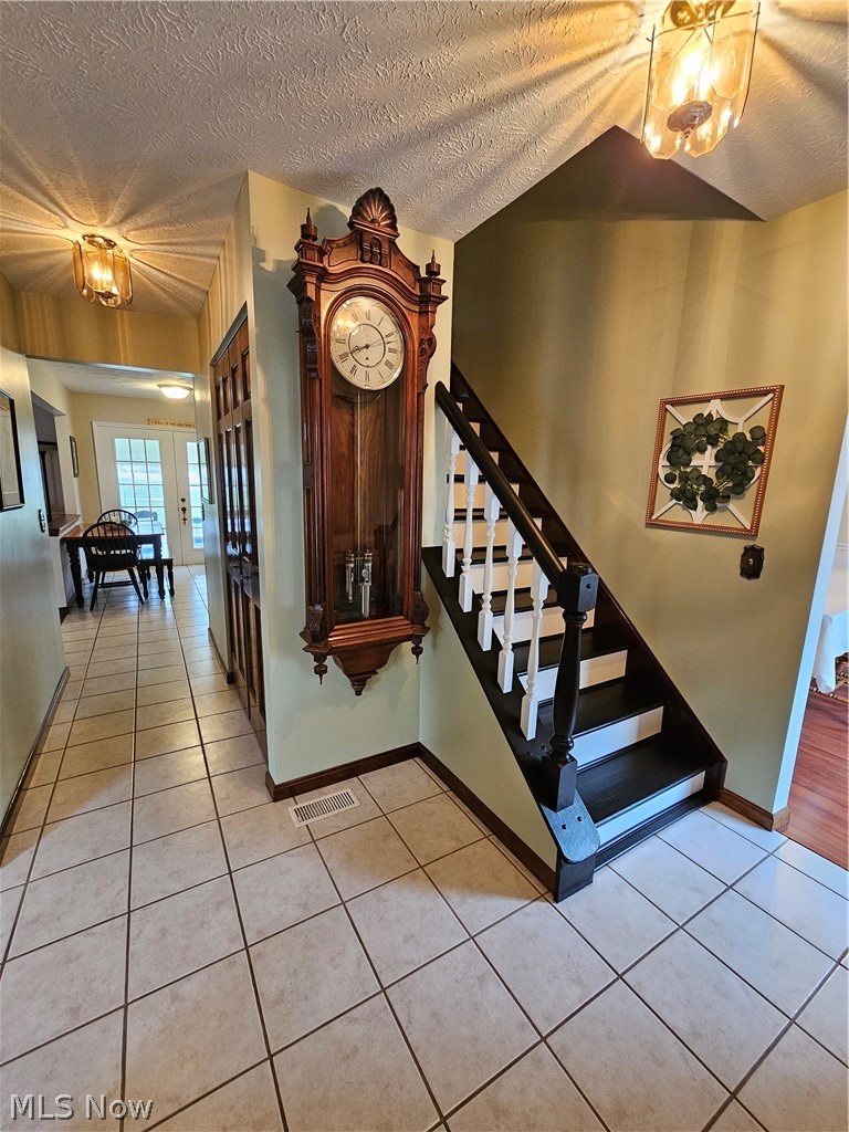 5100 Pierce Road Northwest Warren, OH 44481 - Photo 10 of 26 Foyer featuring a notable chandelier, a textured ceiling, and light ceramic tile floors