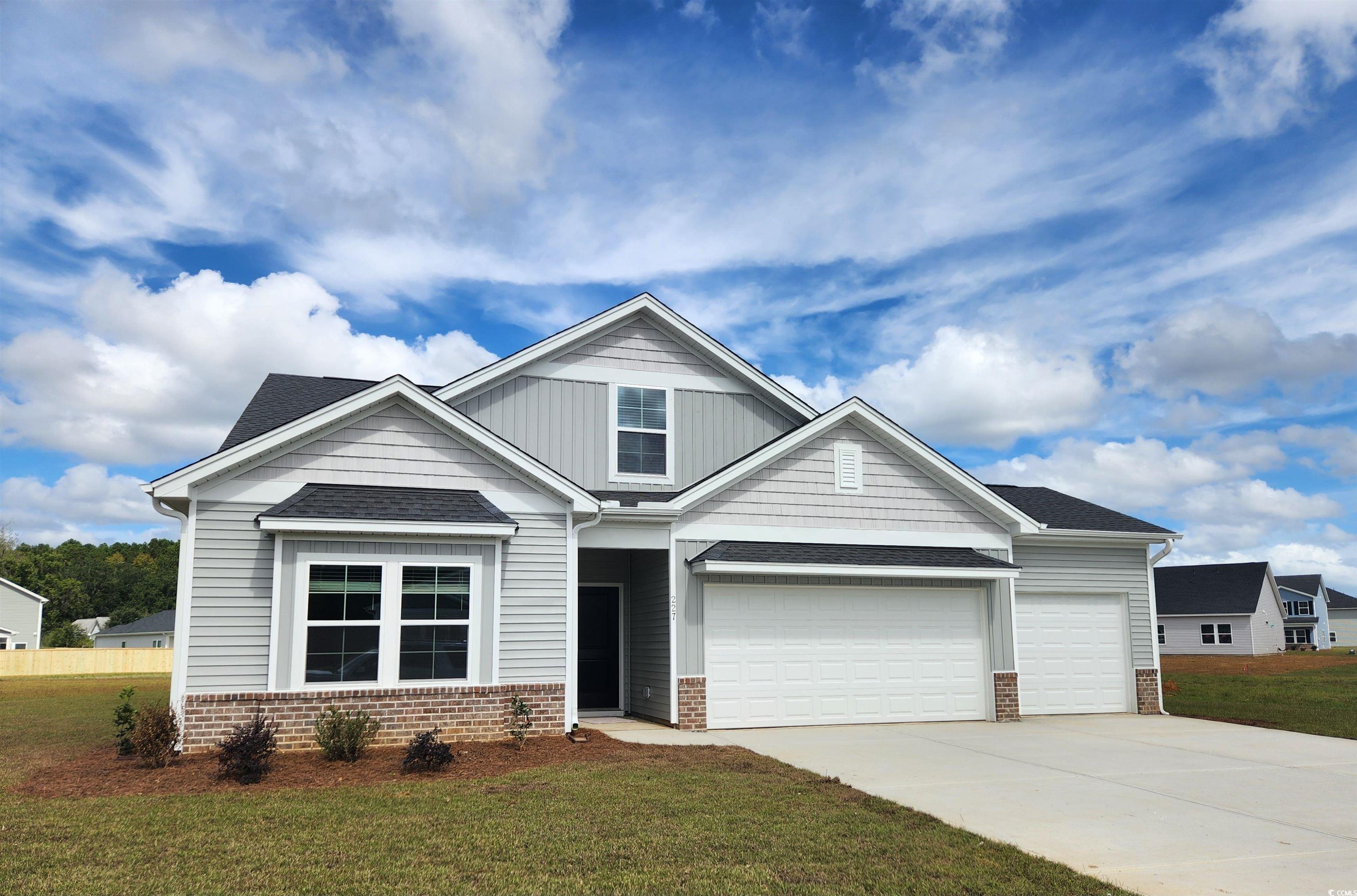 227 Sundrop Way Conway, SC 29526 - Photo 1 of 1 Craftsman-style house with board and batten siding, concrete driveway, a front yard, a shingled roof, and brick siding