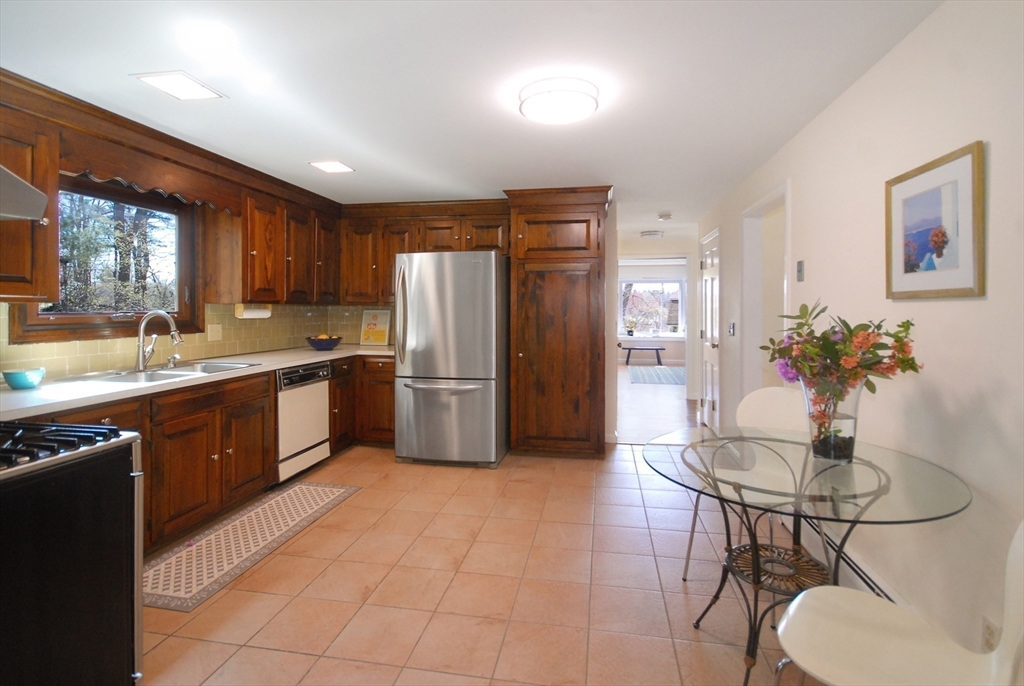 1 Pomfret Road Chelmsford, MA 01824 - Photo 12 of 28 a kitchen with stainless steel appliances a sink a stove a refrigerator dining table and chairs