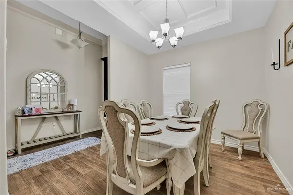 a dining room with furniture a chandelier and wooden floor
