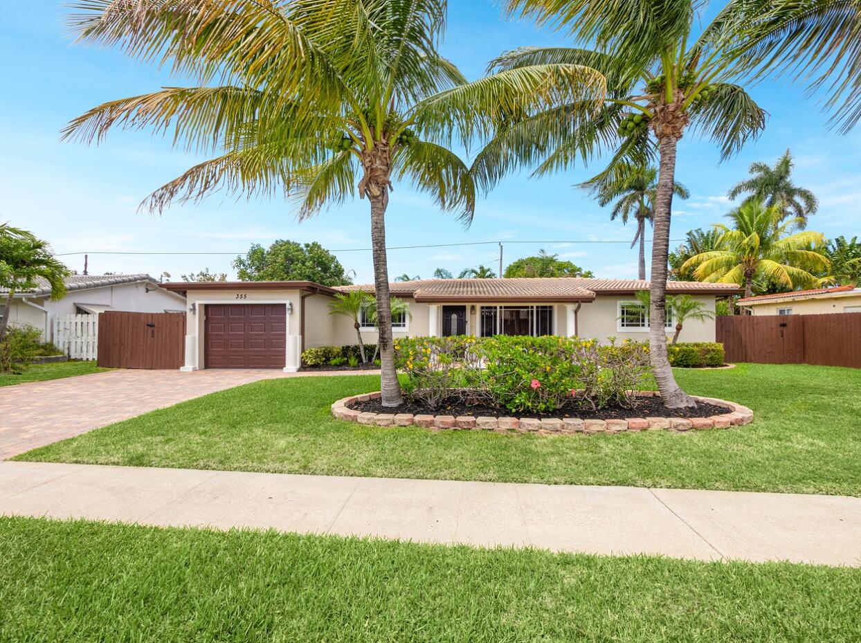 355 Northeast 24th Street Boca Raton, FL 33431 - Photo 1 of 15 a front view of a house with a garden