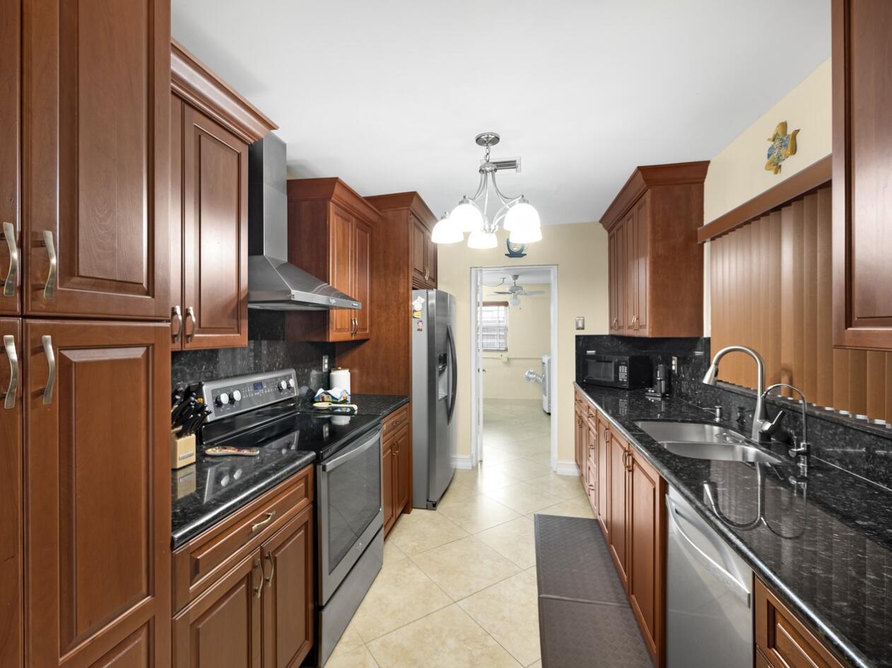 355 Northeast 24th Street Boca Raton, FL 33431 - Photo 5 of 15 a kitchen with granite countertop stainless steel appliances and wooden cabinets