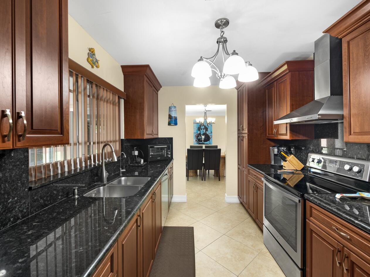 355 Northeast 24th Street Boca Raton, FL 33431 - Photo 6 of 15 a kitchen with stainless steel appliances granite countertop a stove a sink and a refrigerator