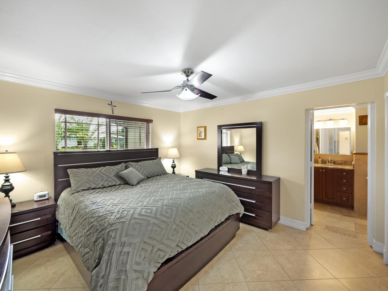 355 Northeast 24th Street Boca Raton, FL 33431 - Photo 7 of 15 a bedroom with a large bed and a chandelier fan