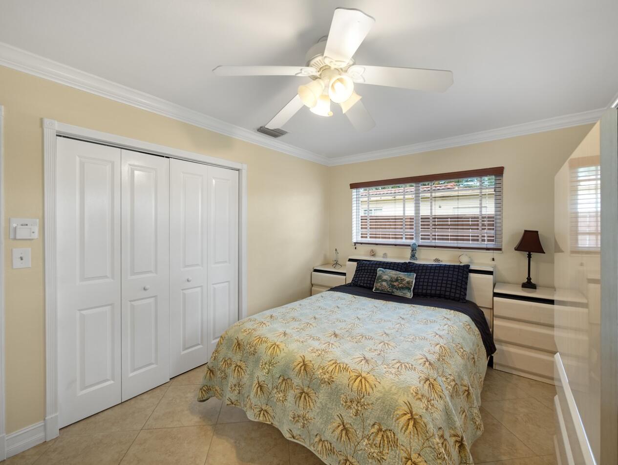 355 Northeast 24th Street Boca Raton, FL 33431 - Photo 9 of 15 a bedroom with a large bed and a chandelier