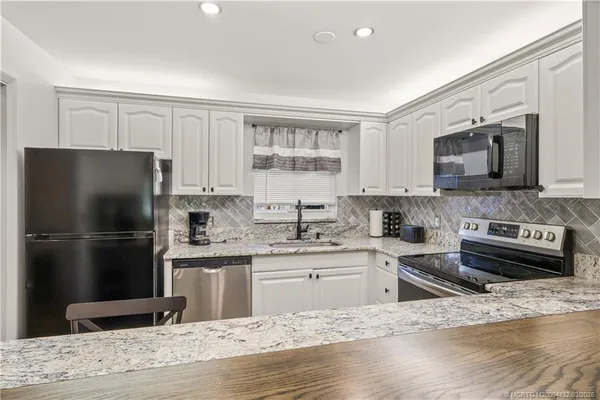 a kitchen with a refrigerator stove and sink