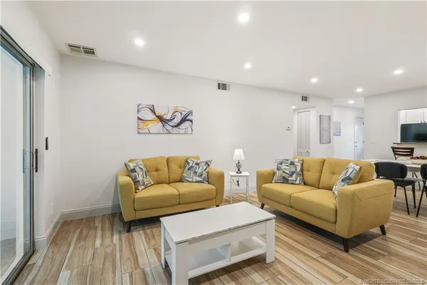 a living room with furniture and a wooden floor