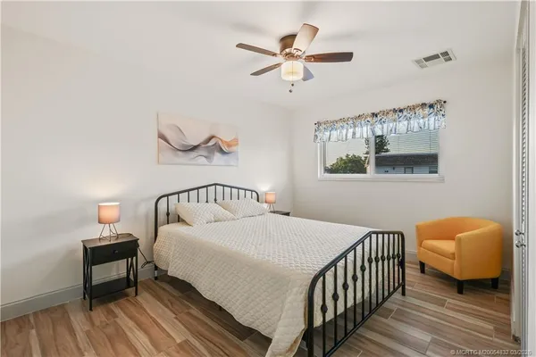 a bedroom with a bed and wooden floor